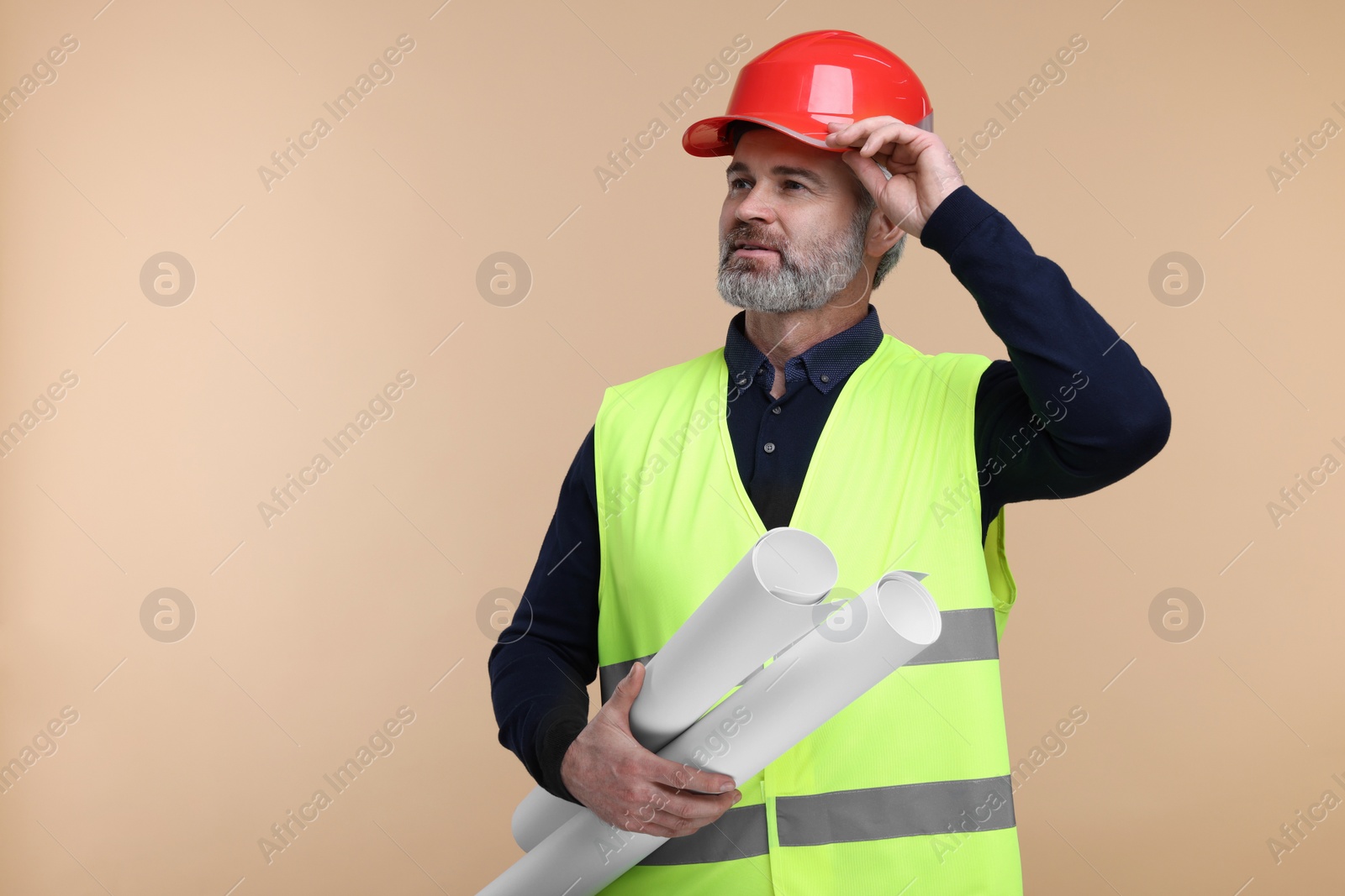 Photo of Architect in hard hat holding drafts on beige background. Space for text