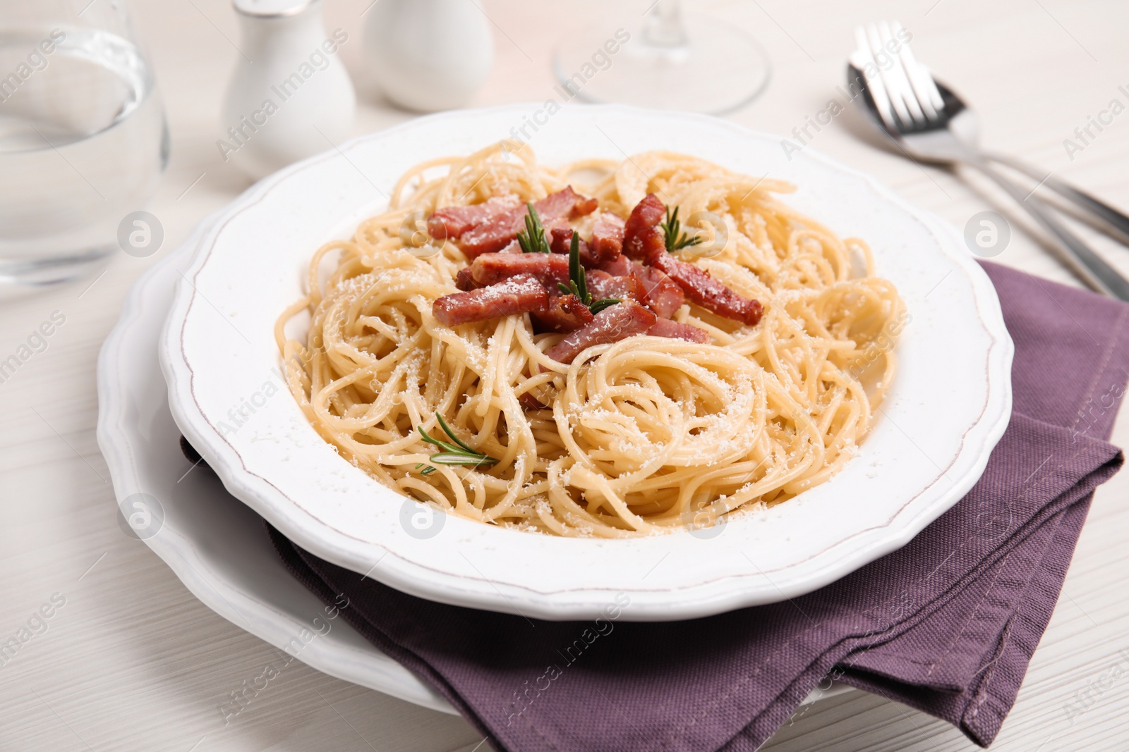 Photo of Delicious Carbonara pasta served on white wooden table