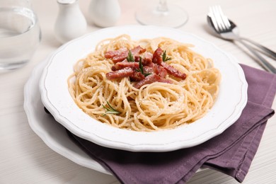 Photo of Delicious Carbonara pasta served on white wooden table