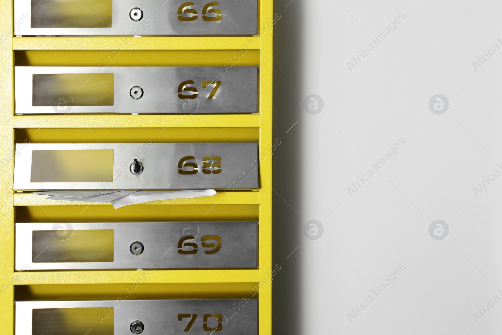Photo of Metal mailboxes with keyholes, numbers and receipts in post office, space for text