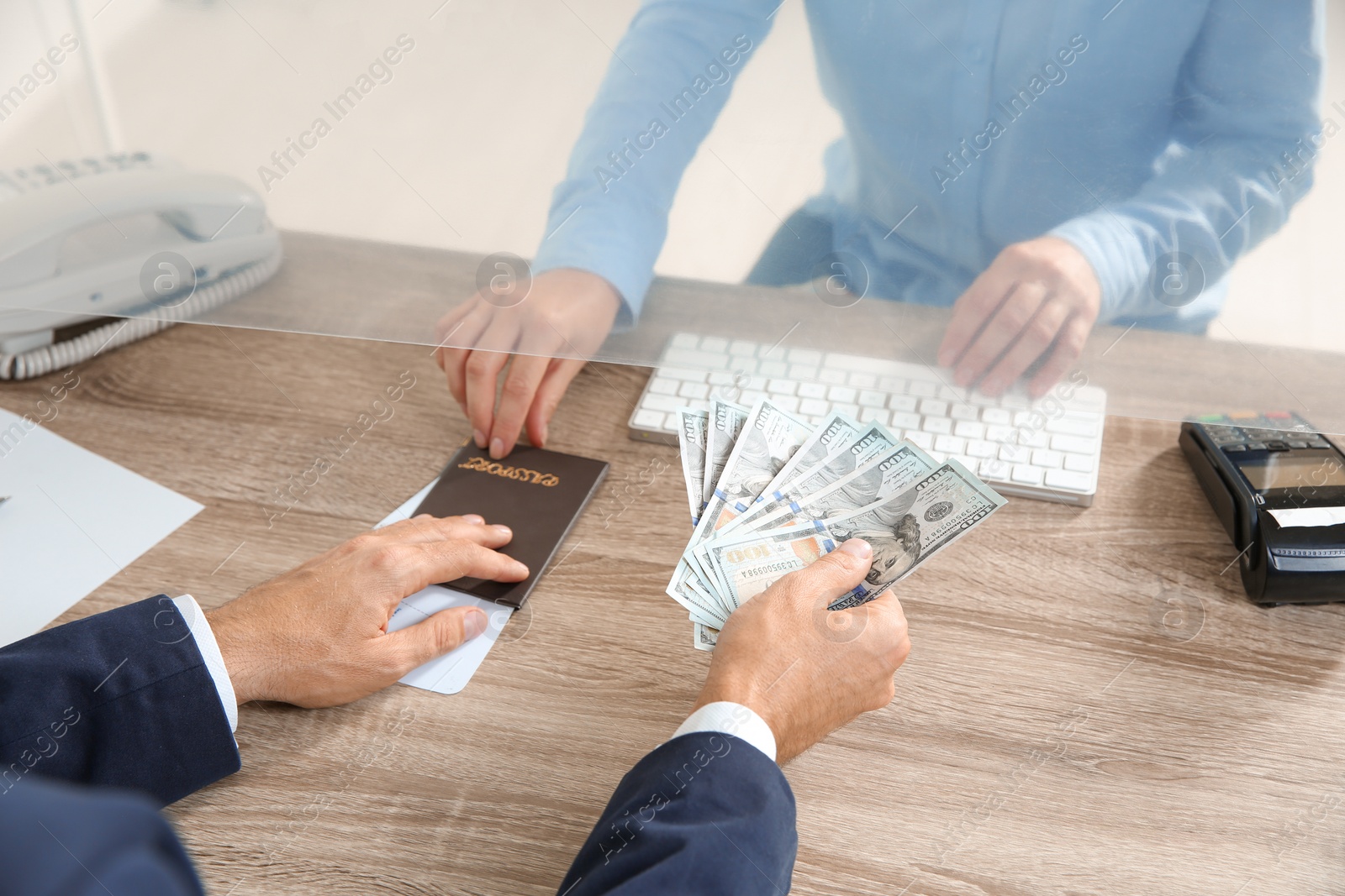 Photo of Man giving money to teller at cash department window, closeup