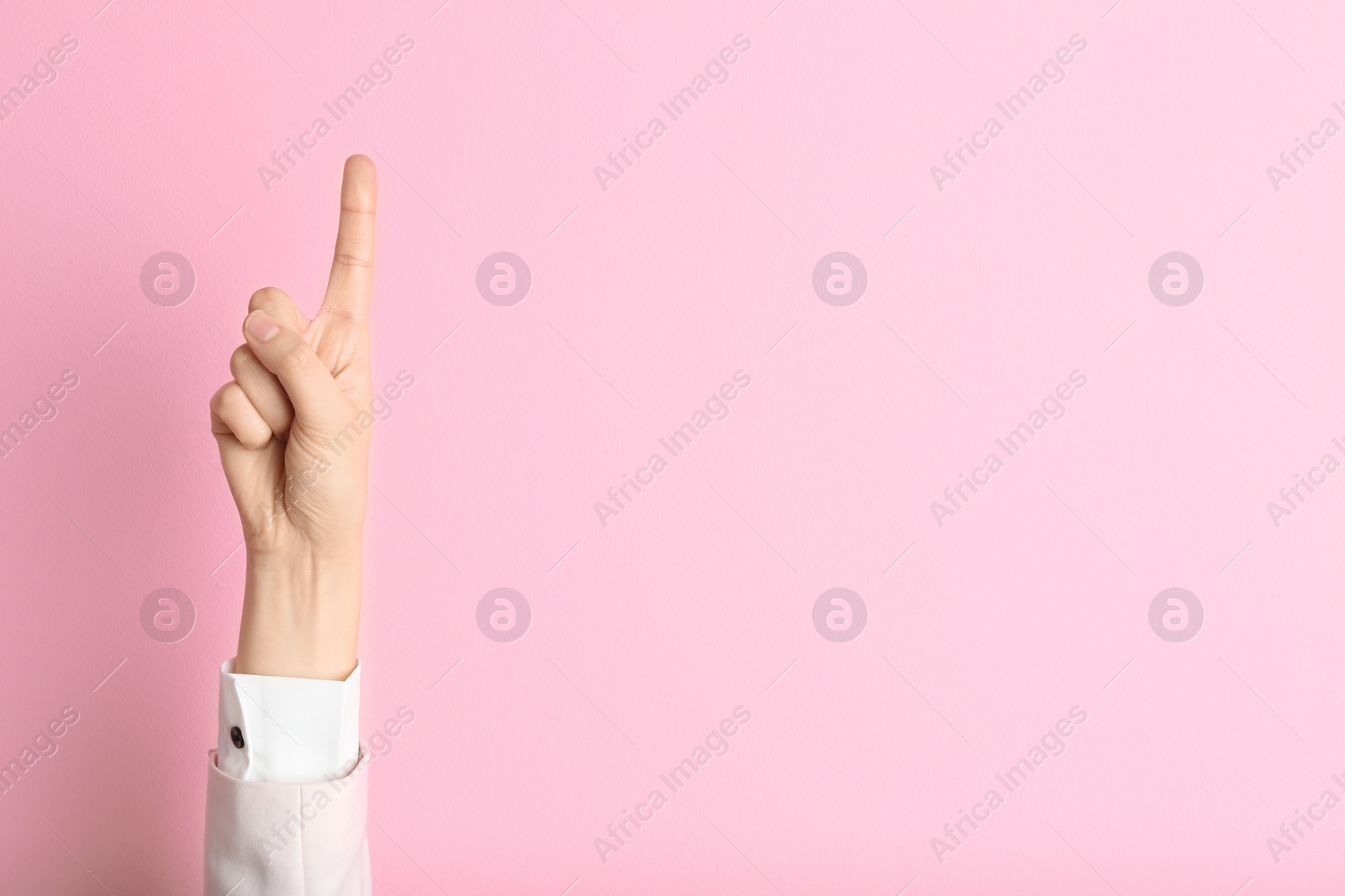 Photo of Young woman with raised index finger on color background. Space for text