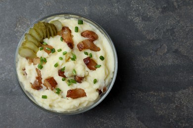 Photo of Potato puree and tasty fried cracklings on grey table, top view with space for text. Cooked pork lard