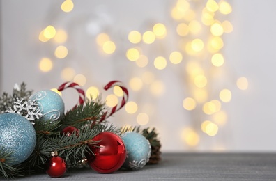 Photo of Christmas decoration on table against blurred lights. Space for text