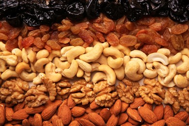Photo of Mix of delicious dried nuts and raisins on beige background