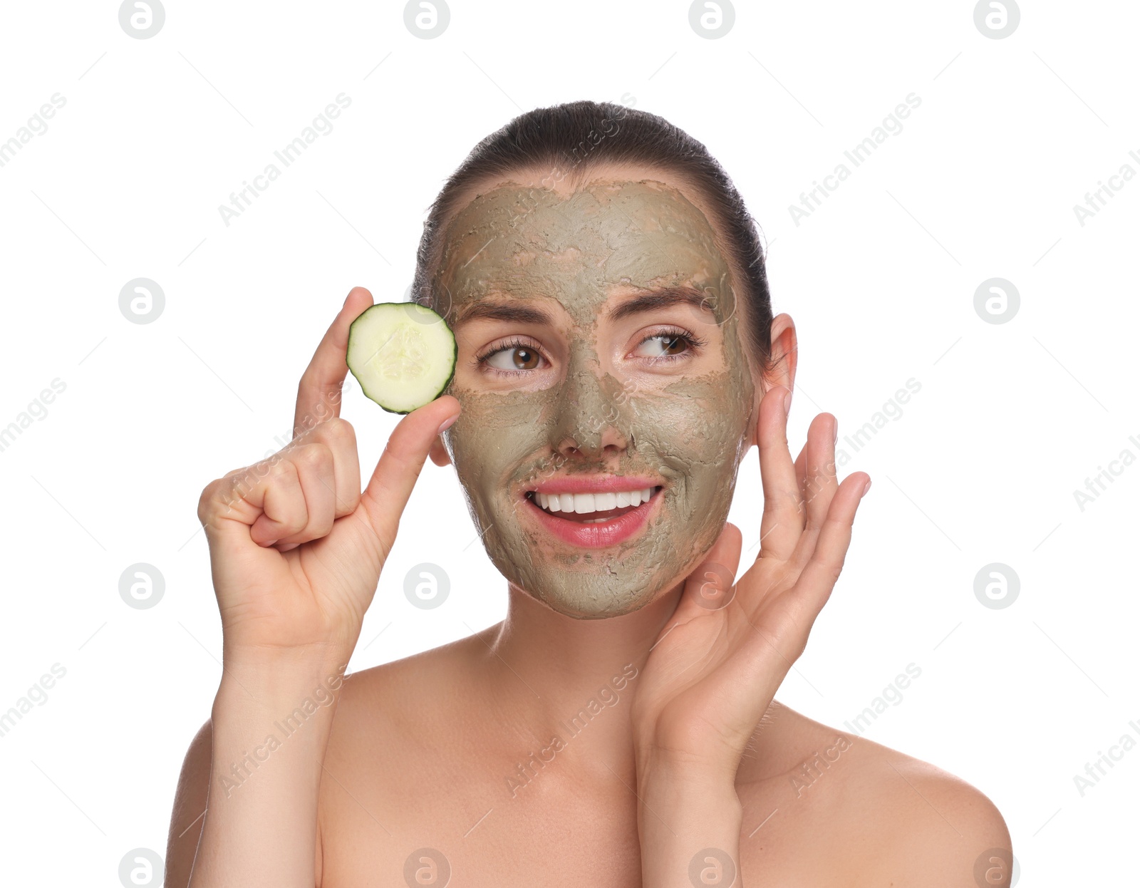 Photo of Beautiful woman with clay mask holding piece of cucumber on white background