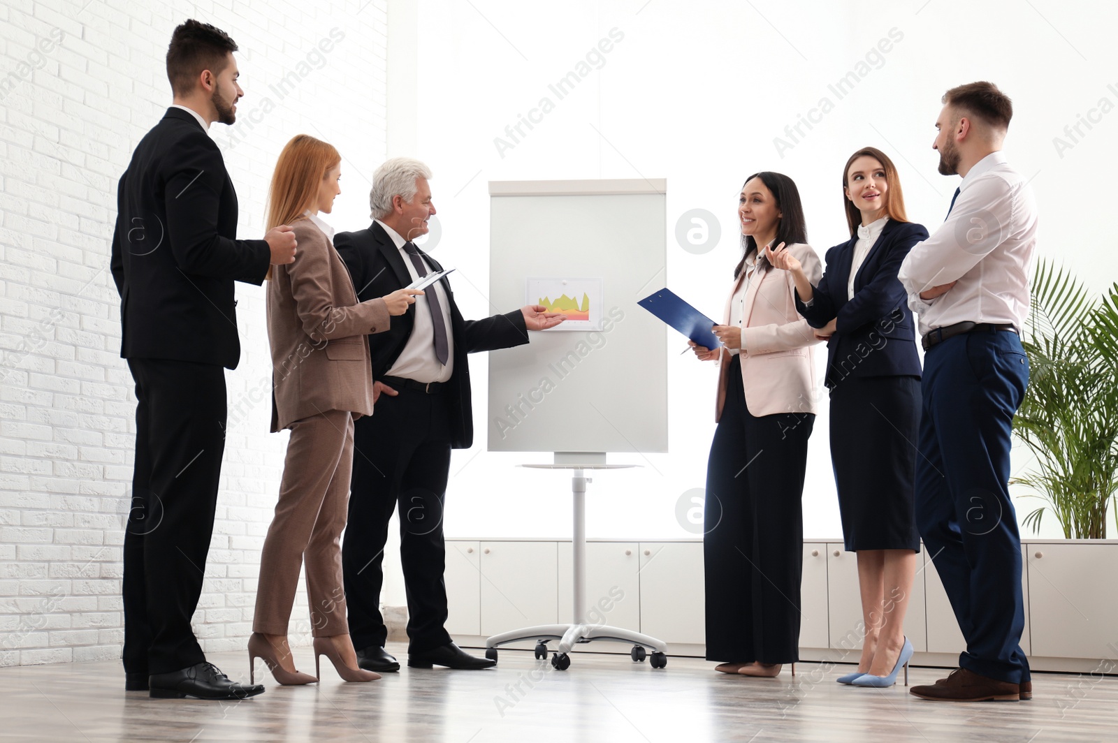 Photo of Senior business trainer working with people in office