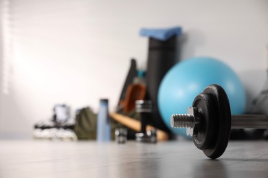 Photo of Dumbbell and other sports equipment indoors, closeup. Space for text