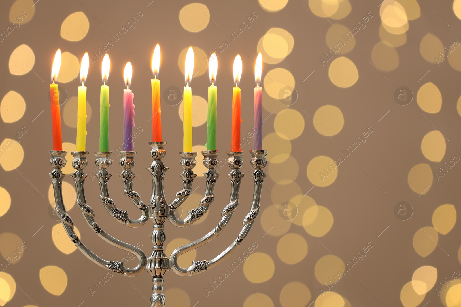 Photo of Hanukkah celebration. Menorah with burning candles against blurred lights, space for text