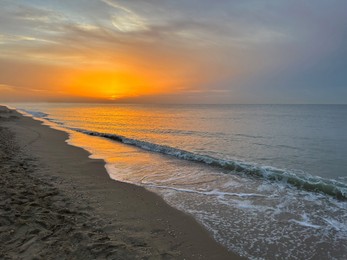 Photo of Beautiful view of sandy beach at sunrise