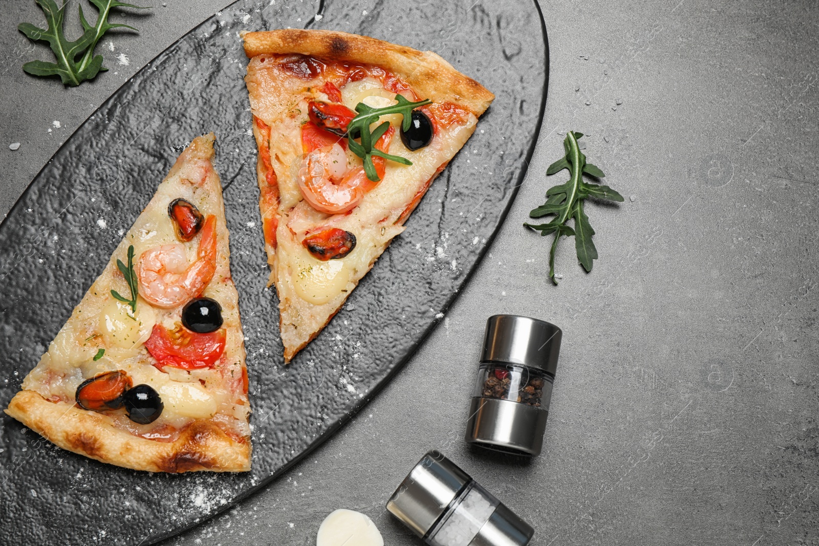 Photo of Tasty pizza with seafood and ingredients on grey table, flat lay