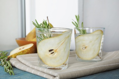 Photo of Refreshing pear cocktail with rosemary on table