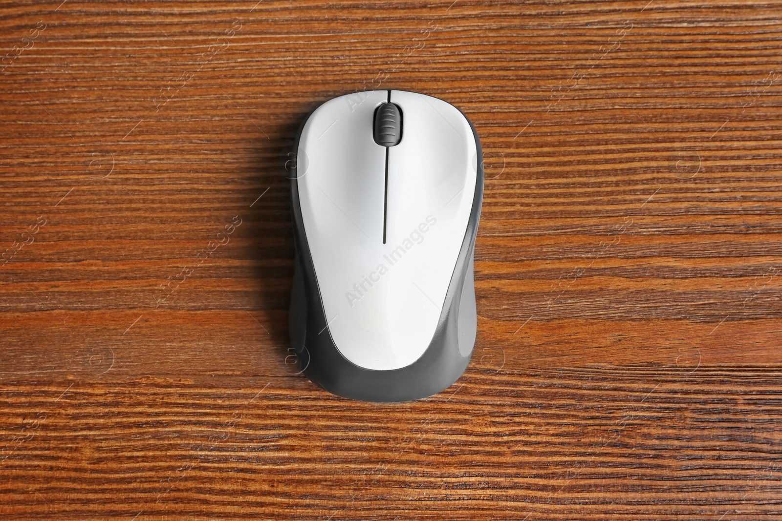 Photo of Wireless computer mouse on wooden background, top view