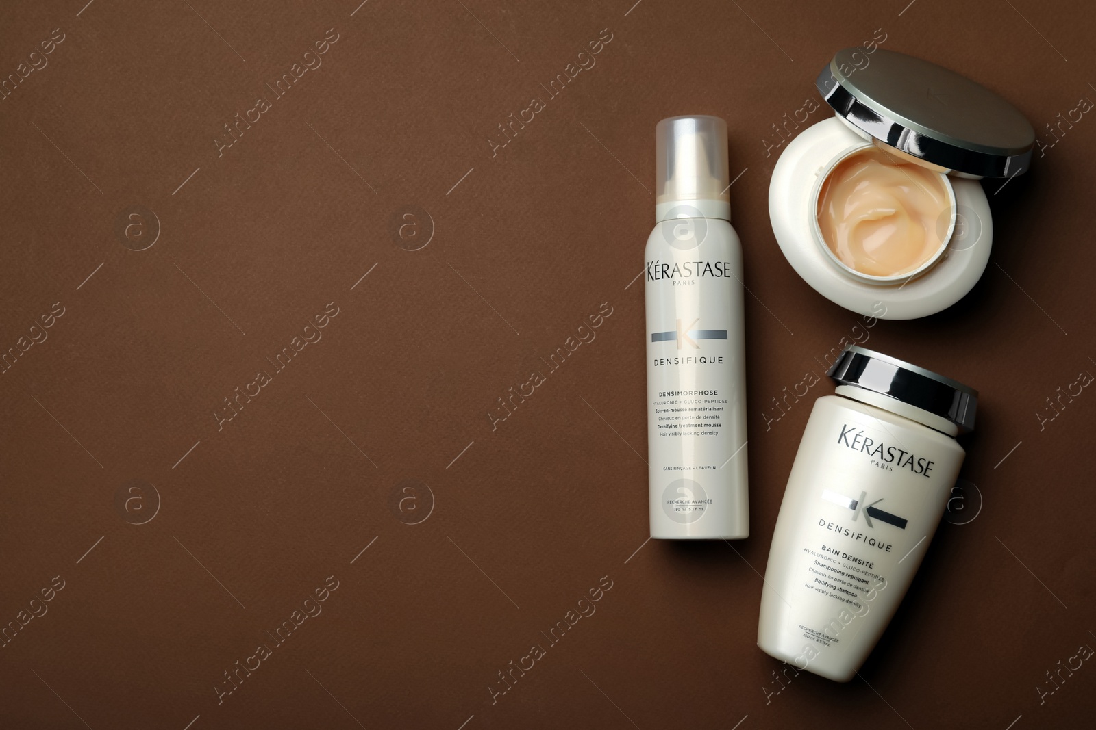 Photo of MYKOLAIV, UKRAINE - SEPTEMBER 07, 2021: Set of Kerastase hair care cosmetic products on brown background, flat lay. Space for text