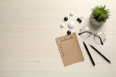 Flat lay composition with unfilled To Do list and houseplant on wooden table