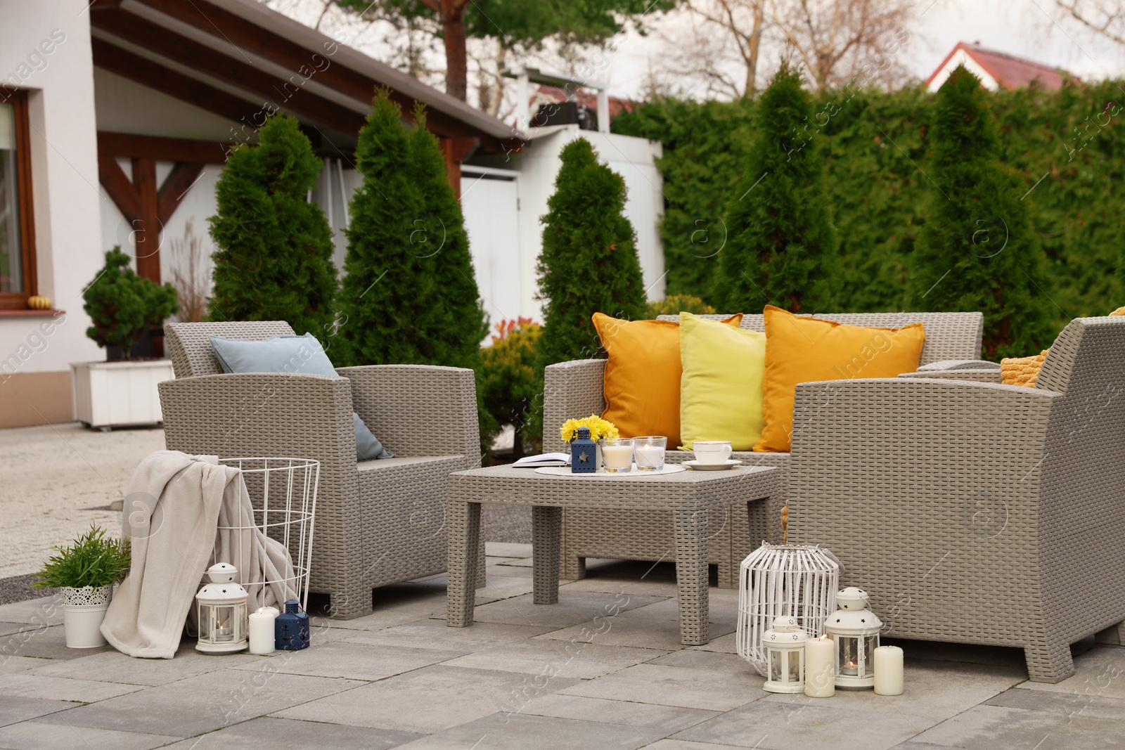 Photo of Beautiful rattan garden furniture, soft pillows and different decor elements in backyard