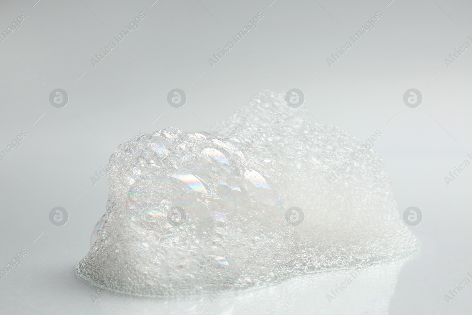 Photo of Drop of fluffy bath foam on light background