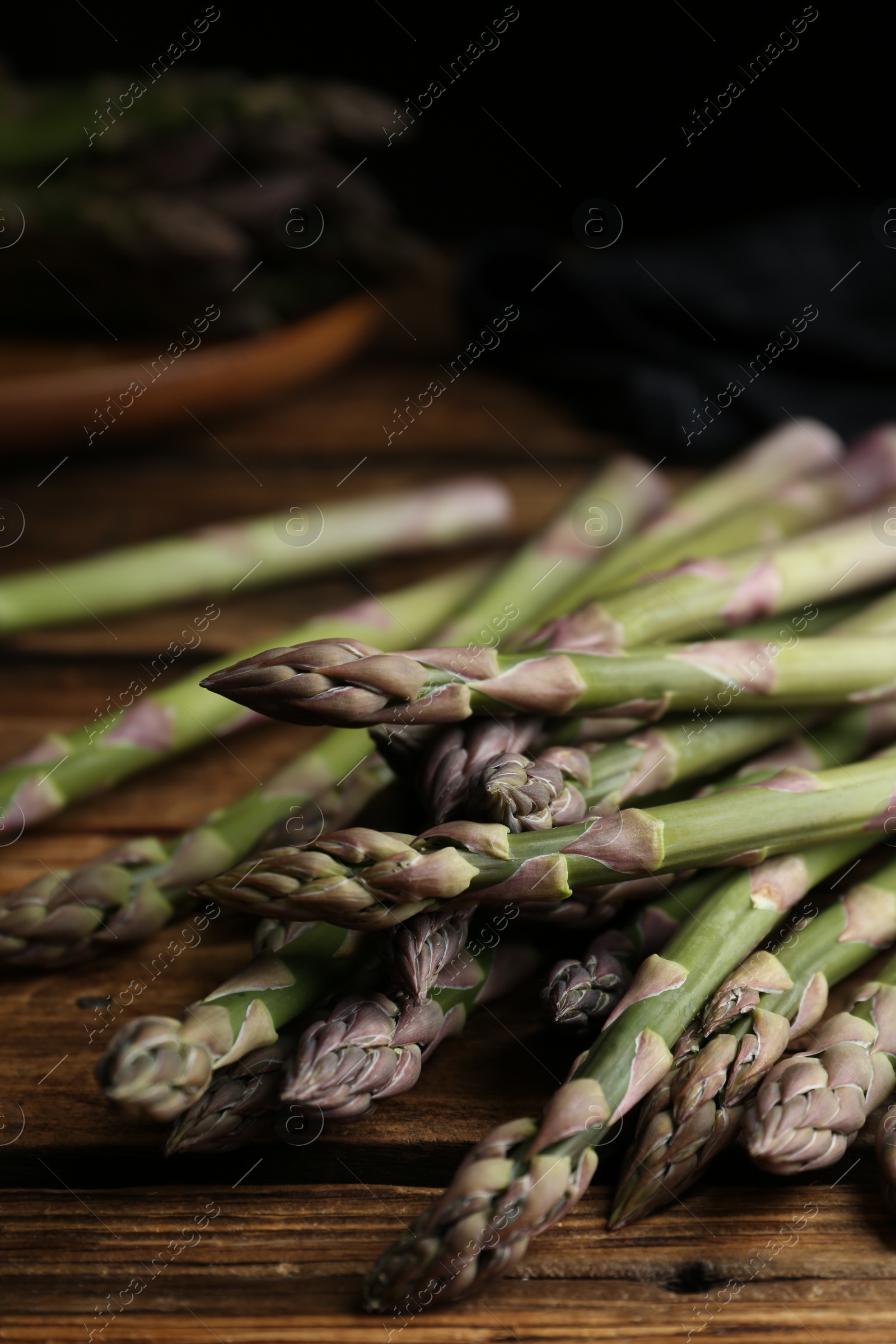 Photo of Fresh raw asparagus on wooden table, closeup