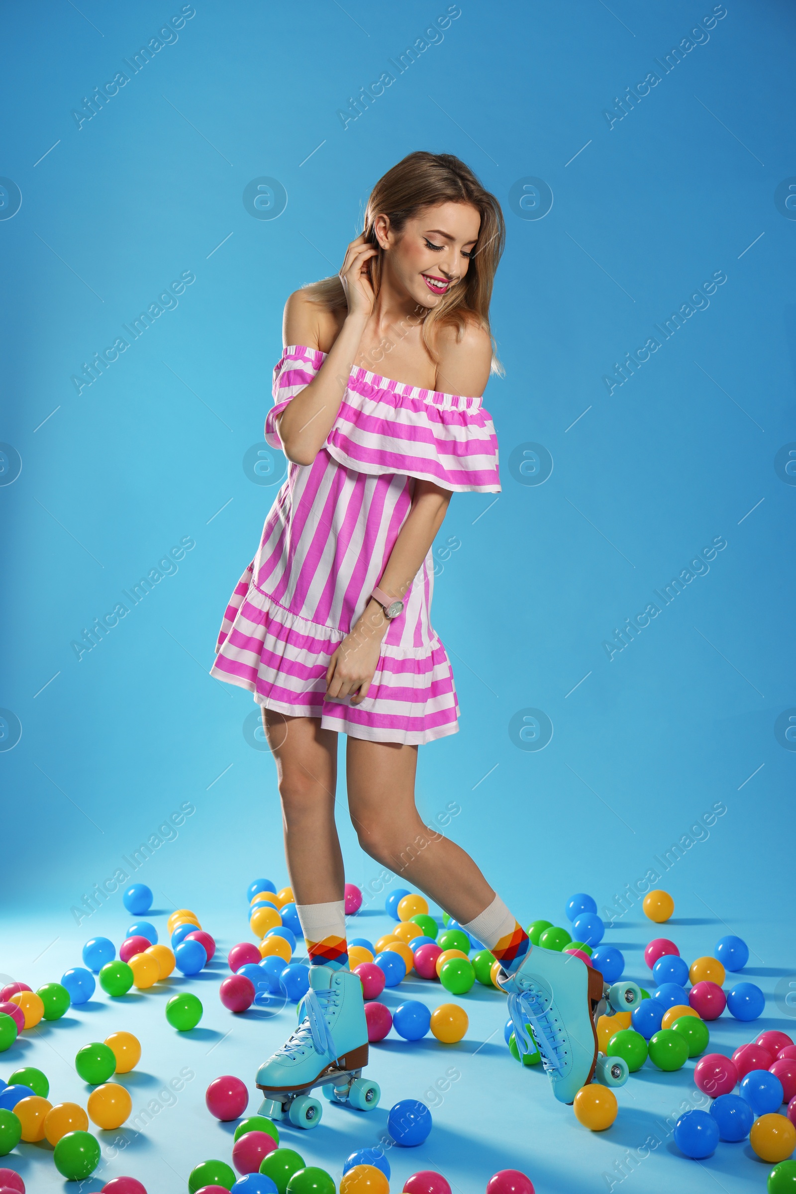 Photo of Young woman with retro roller skates on color background