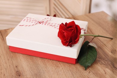 Photo of Gift box and beautiful red rose on wooden table indoors. Happy Valentine's Day