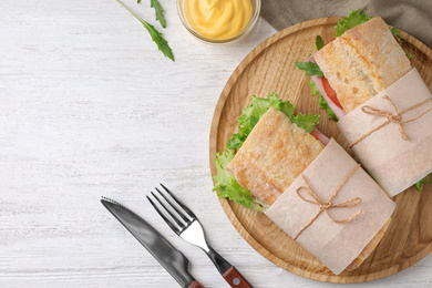 Photo of Tasty sandwiches with ham served on white wooden table, flat lay