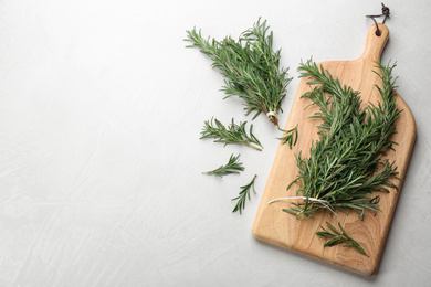 Photo of Bunches of fresh rosemary on light table, above view. Space for text