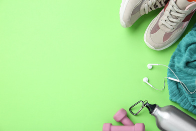 Flat lay composition with sport items on green background. Space for text