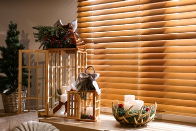 Photo of Beautiful Christmas lanterns on windowsill in decorated room