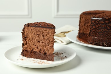 Piece of delicious chocolate truffle cake on white table