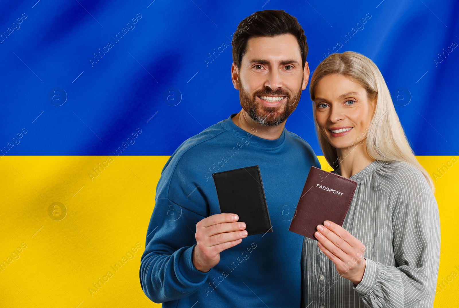 Image of Immigration. Happy man and woman with passports against national flag of Ukraine, space for text