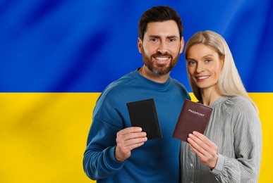 Immigration. Happy man and woman with passports against national flag of Ukraine, space for text