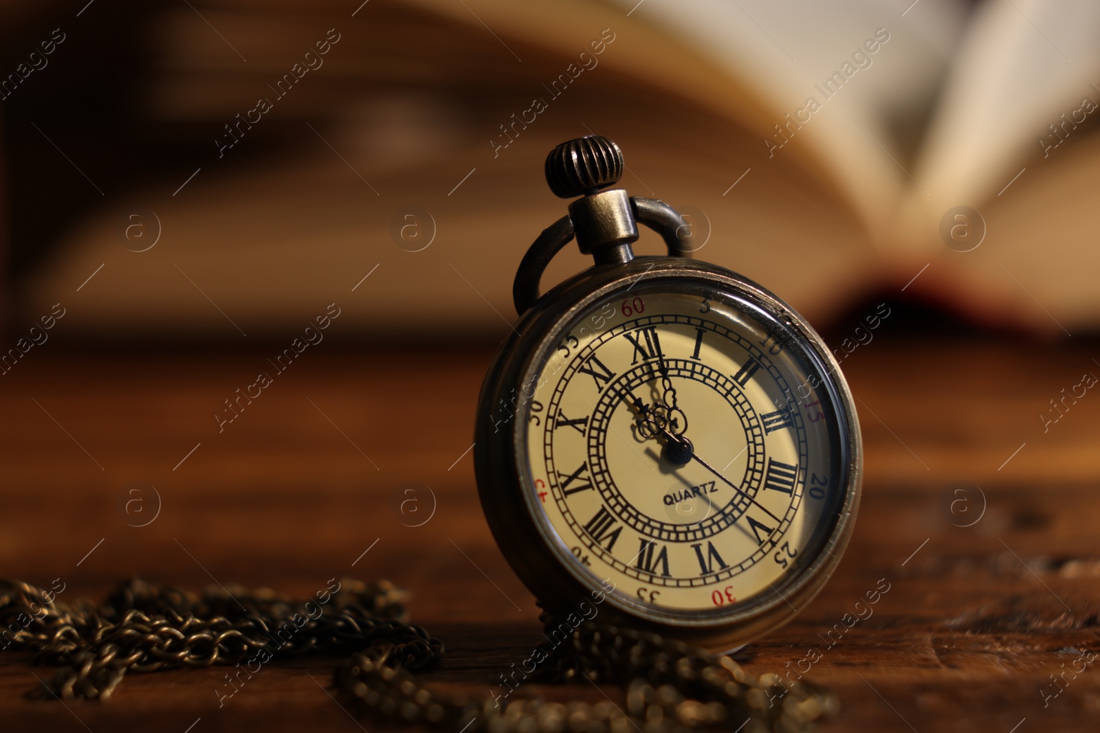 Photo of Pocket clock with chain on table, closeup