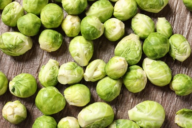 Photo of Fresh Brussels sprouts on wooden table, top view