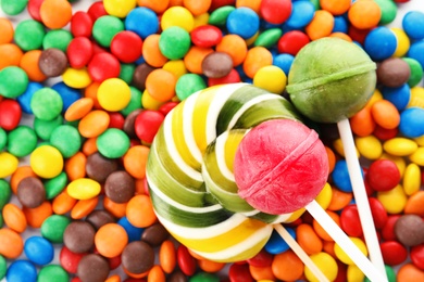 Photo of Lollipops and colorful candies as background, top view