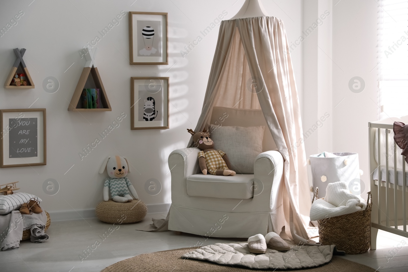 Photo of Stylish baby room interior with crib and comfortable armchair