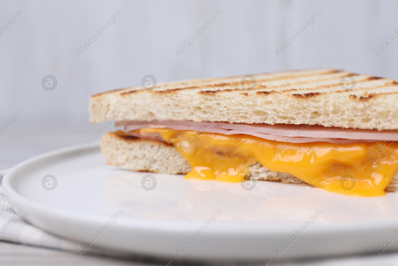 Delicious grilled sandwich with ham and cheese on table, closeup Photo of Delicious grilled sandwich with ham and cheese on table, closeup