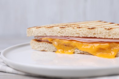 Photo of Delicious grilled sandwich with ham and cheese on table, closeup