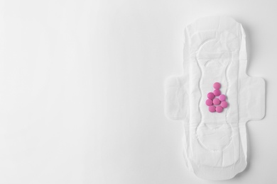 Photo of Menstrual pad and pills on white background, top view with space for text. Gynecological care