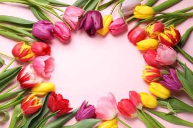 Photo of Frame made with beautiful spring tulips on pink background, top view. Space for text