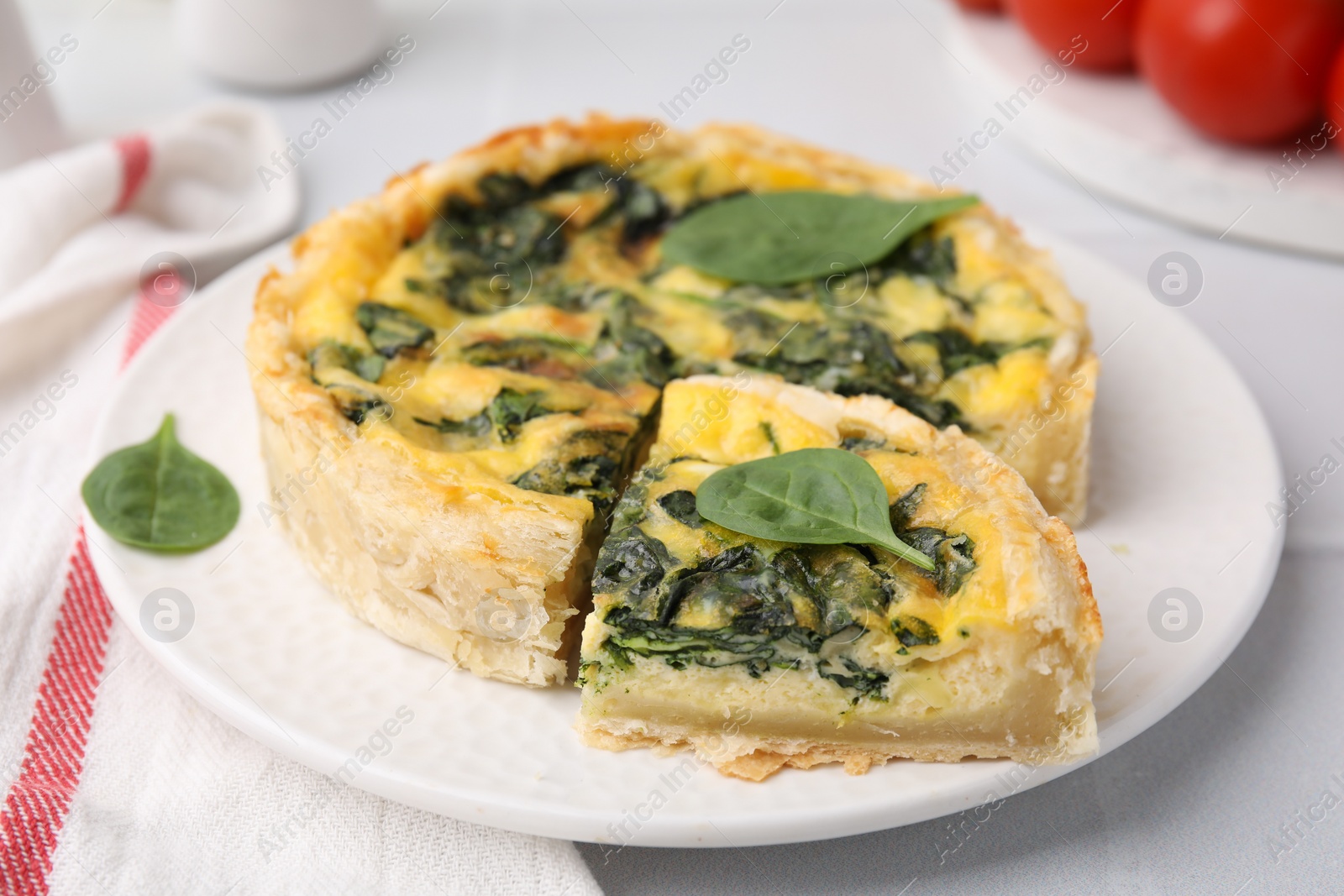 Photo of Delicious pie with spinach on white table, closeup