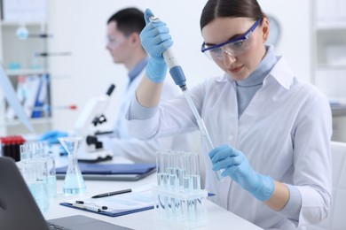 Scientist dripping sample into test tube in laboratory