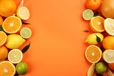 Flat lay composition with tangerines and different citrus fruits on orange background. Space for text