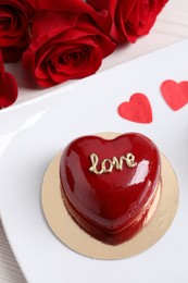 Photo of St. Valentine's Day. Delicious heart shaped cake and roses on table