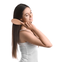 Beautiful young woman with hair brush on white background