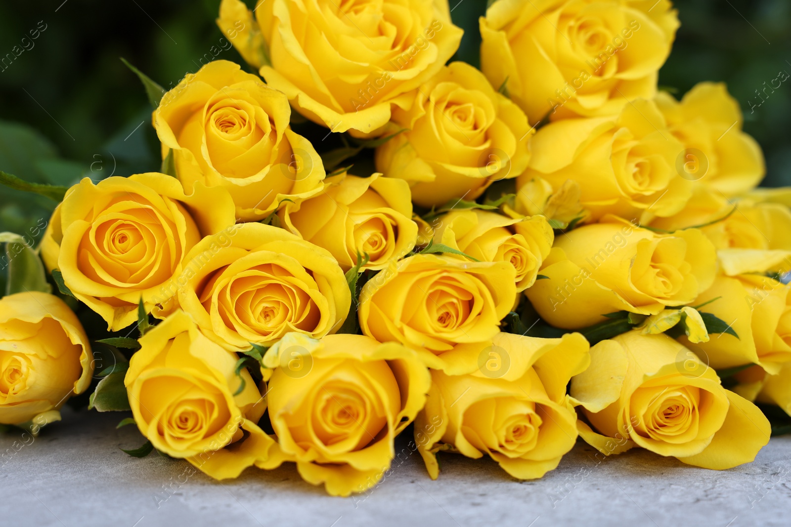 Photo of Beautiful bouquet of yellow roses on light table, closeup