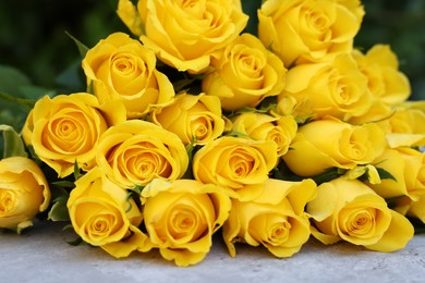 Photo of Beautiful bouquet of yellow roses on light table, closeup