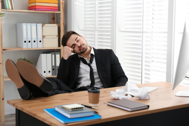 Photo of Lazy employee sleeping at table in office