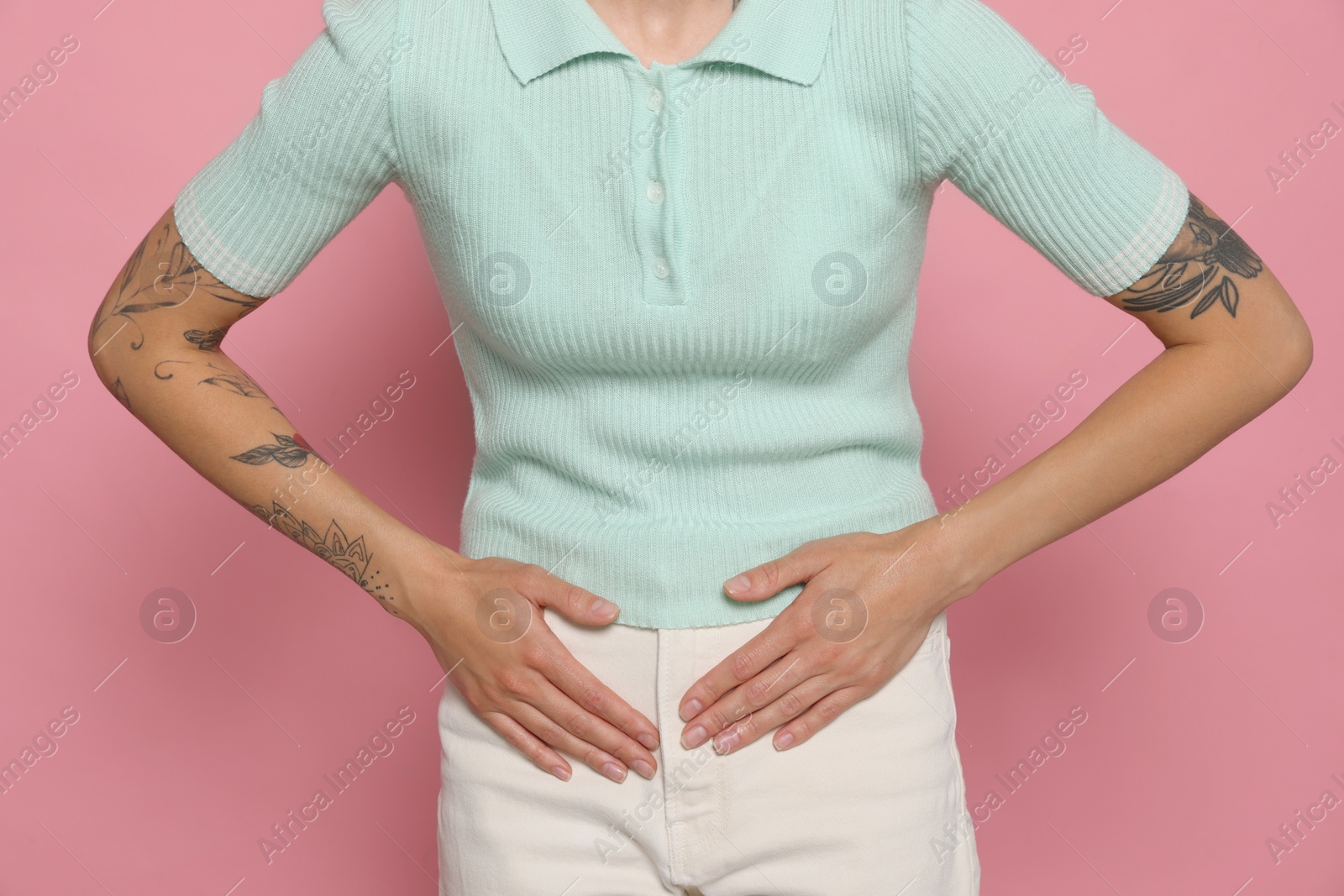 Photo of Young woman suffering from menstrual pain on pink background, closeup