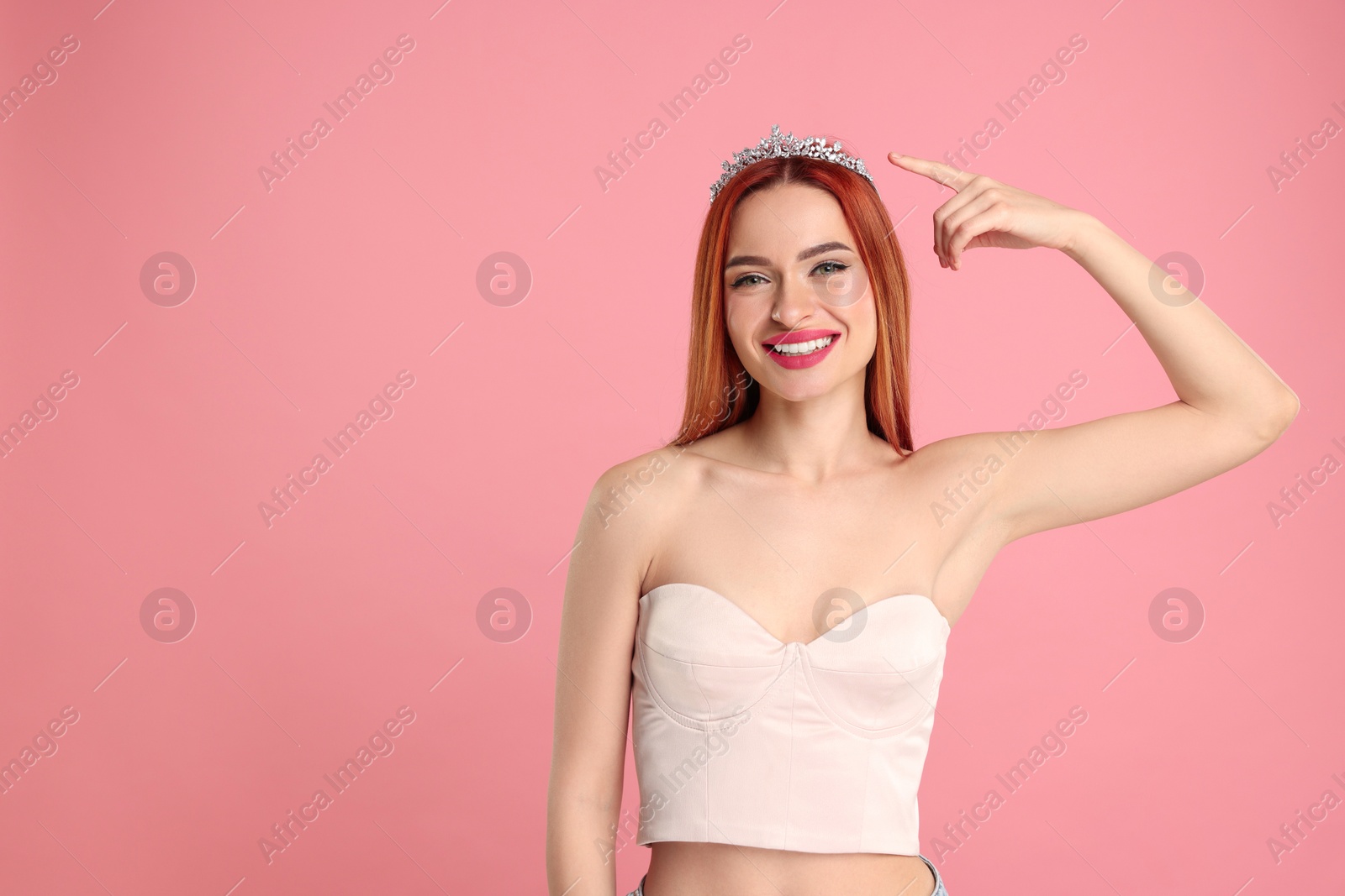 Photo of Beautiful young woman with tiara on pink background, space for text