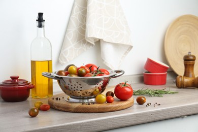 Photo of Metal colander with tomatoes on countertop in kitchen